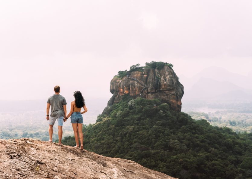 A couple in love on a rock admires the beautiful views. A couple in love travels
