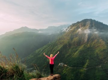 Girl meets sunrise in the mountains. Girl traveling to Sri Lanka. Mountain sports